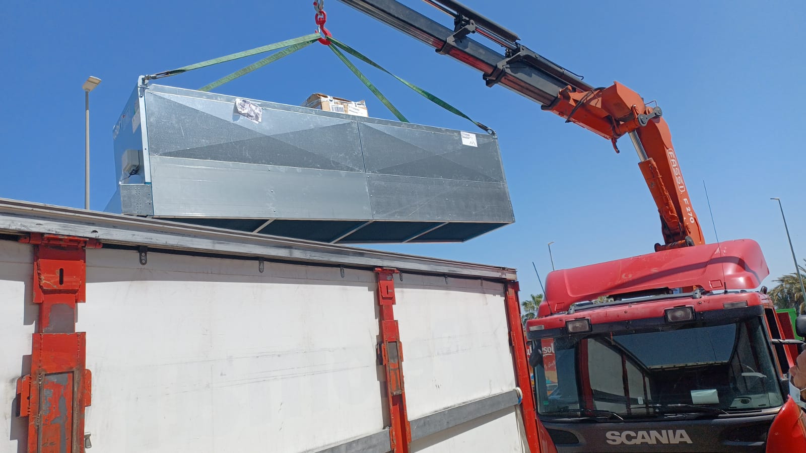 Transporte con grúa levantando maquinaria pesada de forma segura y eficiente. Servicios de grúa para transporte profesional y manipulación de cargas pesadas.